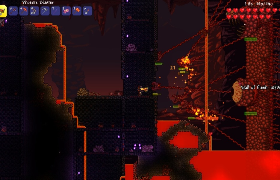 A Terraria player fighting the Wall of Flesh boss in the Underworld above lava